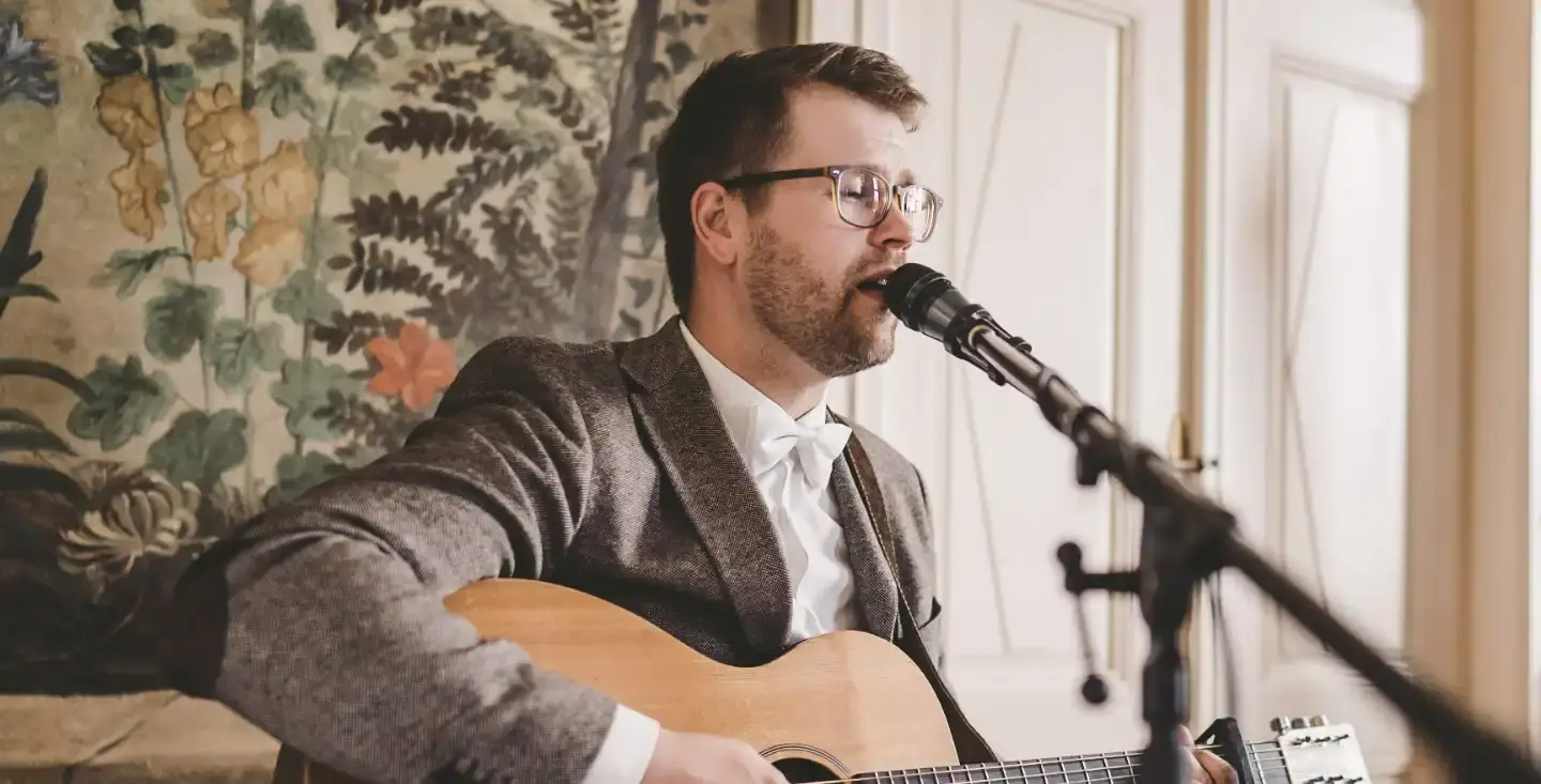 Live-Musik mit Gitarre zum Sektempfang auf einem Hausboot: Mathias Gromeier sorgt für Stimmung am See